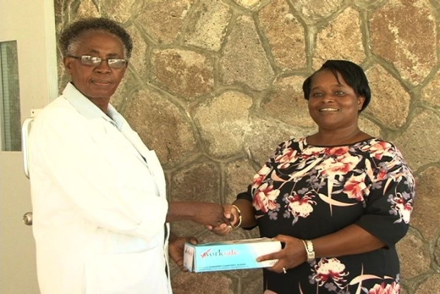 (L-R) Nurse Manager at the Flamboyant Nursing Home Ms. Ena Sutton receives donation from Nevisian Ms. Earlene Byron and other members of her family all based in the United Kingdom.